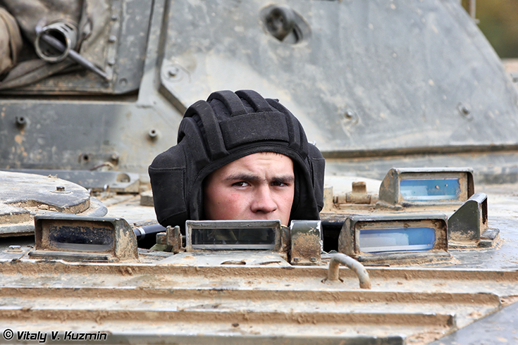 A BMP-2 (*amphibious infantry vehicle) driver looks out of the driver's hatch during the annual inspection by the commission of the Western Military District in October of 2011. (Image courtesy: Vitaly Kuzmin*)