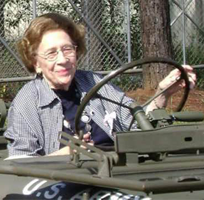A square photograph shows an elderly woman wearing glasses and a long-sleeve, collared shirt sitting at the wheel of a Jeep. This image is the eleventh in a series of 12 accompanying the article.