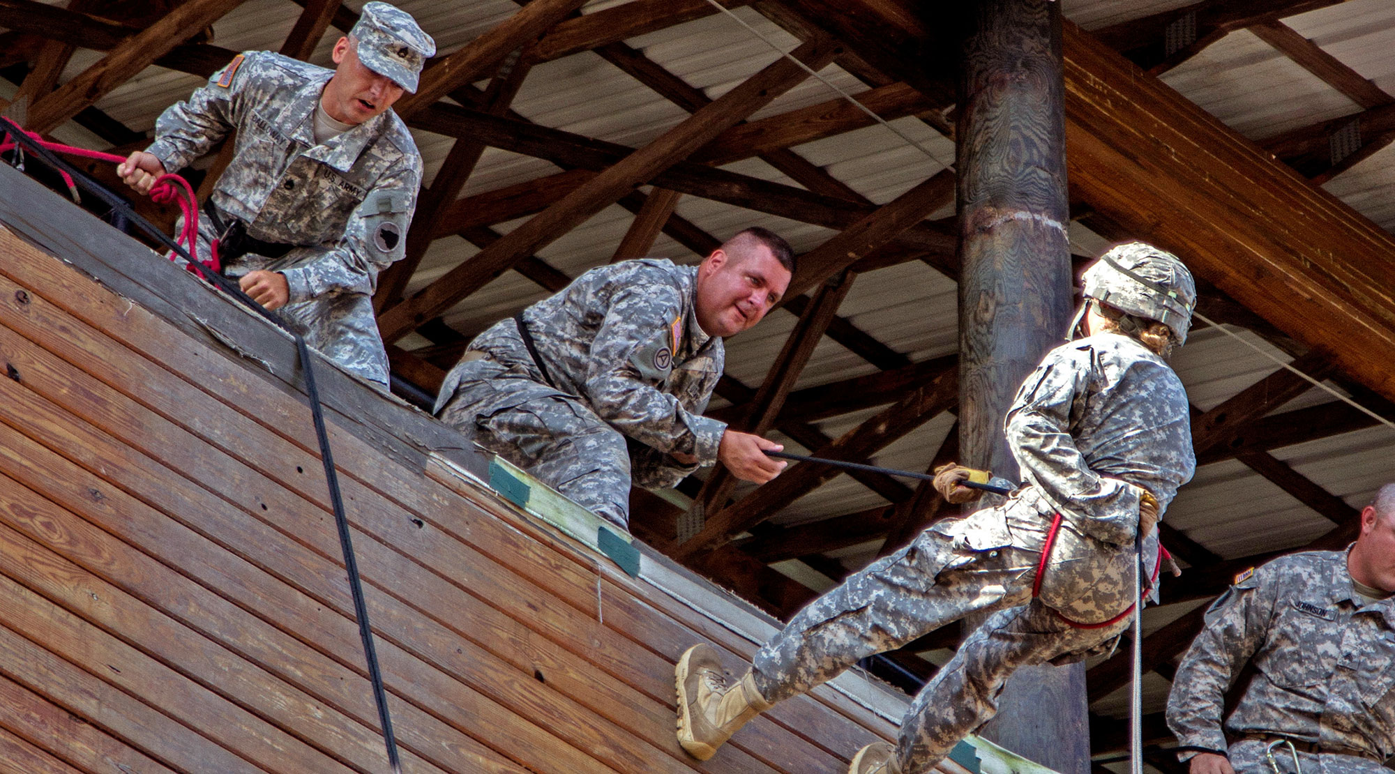 Task Force Wolf, Army Reserve instructors from Alpha Company, 399th Training Support Battalion (ROTC), assists Cadet Initial Entry Training (CIET) candidates in rappeling the High Wall during Cadet Summer Training on July 23 at Ft. Knox, Kentucky. (Photo by Sgt. Karen Sampson)