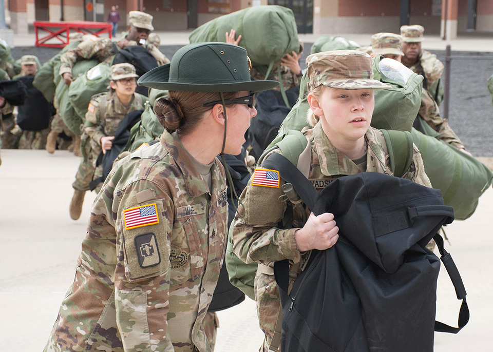 A U.S. Army drill sergeant corrects a recruit during her first day of training at Fort Leonard Wood, Mo., Jan. 31, 2017. Referred to as “Day Zero” this marks the beginning of the recruit's journey through Basic Combat Training, where she will transition from a civilian to a Soldier. (U.S. Army photo by Stephen Standifird)