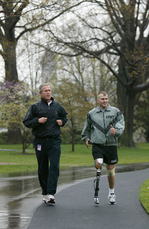 President George W. Bush runs with U.S. Army Staff Sgt. Michael J. McNaughton on the South Lawn on April 14, 2004. The two met Jan. 17, 2003, at Walter Reed Army Medical Center, where McNaughton was recovering from wounds sustained in Afghanistan. The President wished McNaughton a speedy recovery so that they might run together in the future. (White House photo)