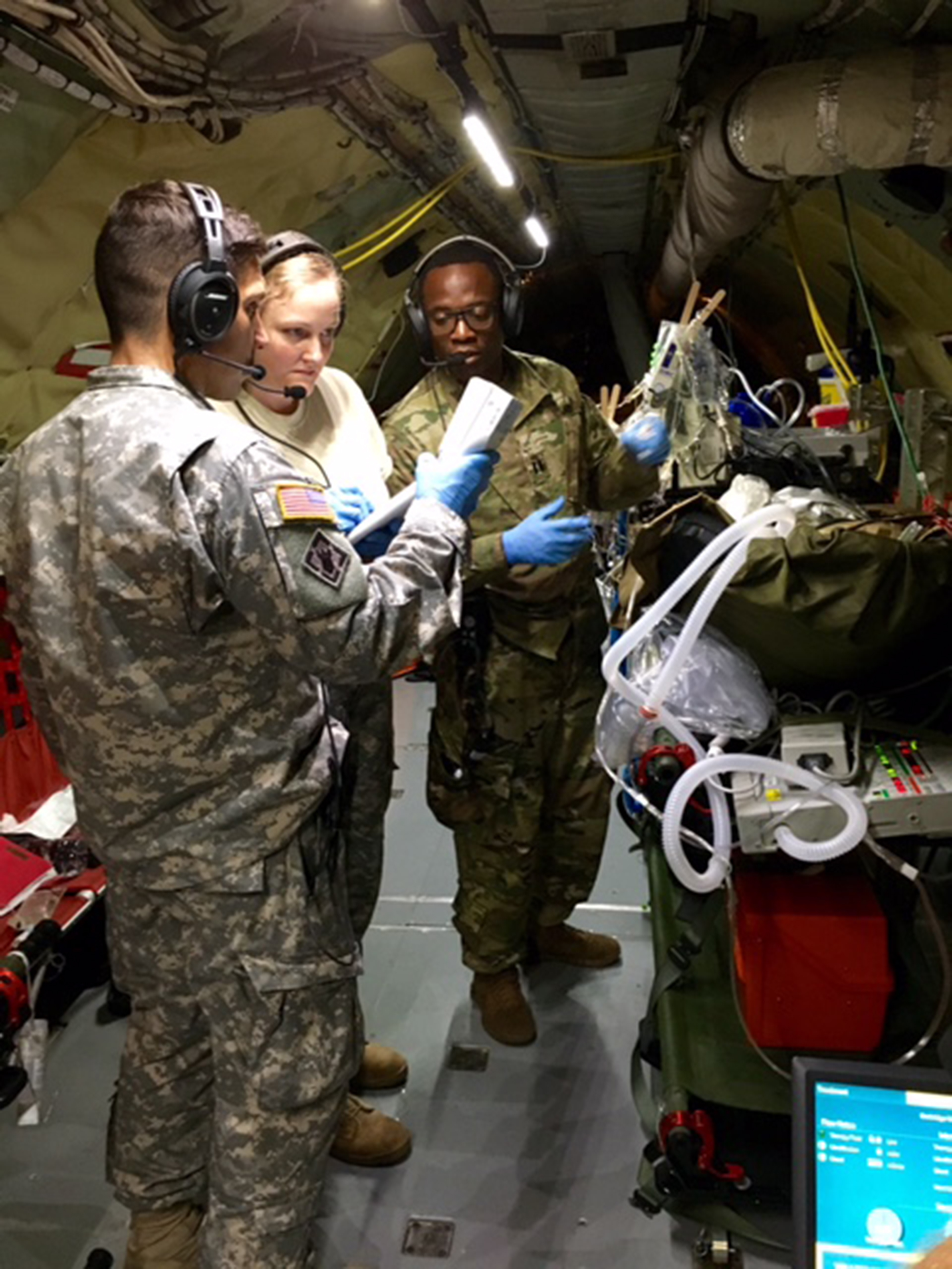 U.S. Army Institute of Surgical Research Burn Flight Team members Staff Sgt. Daniel Zimmerman, Capt. Sarah Hensley and Capt. Kirt Cline monitor a patient during a record-breaking mission from Singapore on Nov. 9, 2015. (U.S. Army photo courtesy of USAISR)