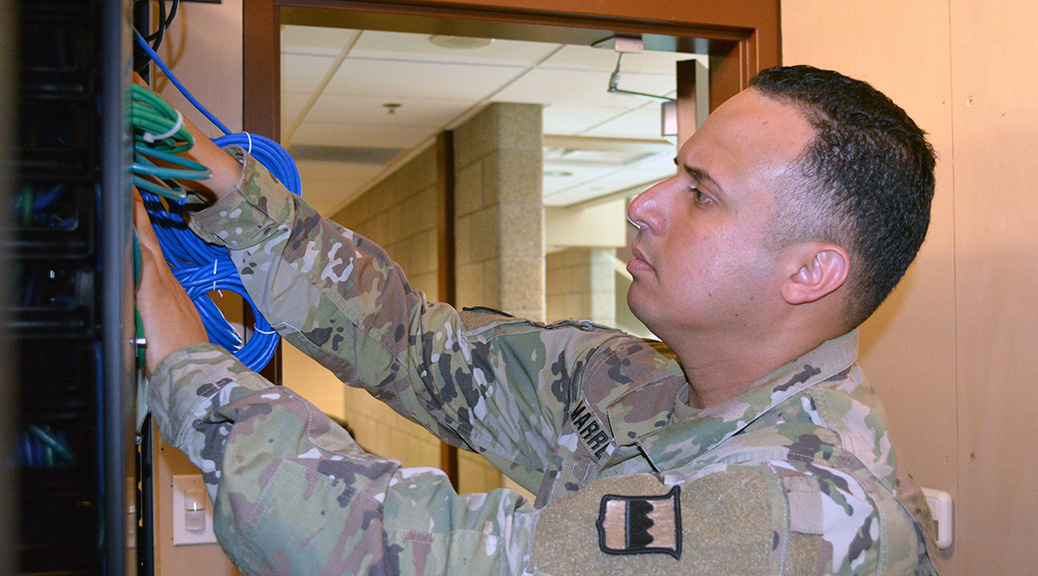 Staff Sgt. Hector Marrero, an information technology specialist assigned to the 80th Training Command, trouble shoots computer connectivity in The Army School System Training Center’s Network Operation Command, in Grand Prairie, Texas. As part of the transition to Army University, experts such as Marrero will have an easier time receiving civilian credentials for their Army expertise. (Photo by Sgt. 1st Class Phillip Eugene)