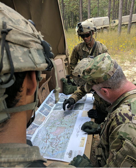 A Civil Affairs team briefs Brig. Gen. Richard K. Sele (bottom right), deputy commanding general, U.S. Army Civil Affairs and Psychological Operations Command (Airborne), on their operations in support of a brigade combat team at the Joint Readiness Training Center. (U.S. Army photo by 1st Lt. David W. Cline)