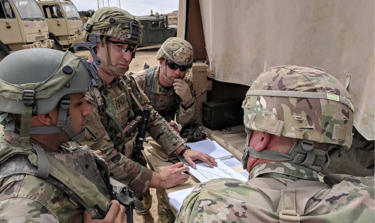A Psychological Operations team briefs Brig. Gen. Richard K. Sele (right), Deputy Commanding General, U.S. Army Civil Affairs and Psychological Operations Command (Airborne), and Master Sgt. Kevin S. Williams (center), G7 Training Directorate NCOIC, USACAPOC (A), on the training strategy leading up to an National Training Center deployment. (U.S. Army photo by 1st Lt. David W. Cline)