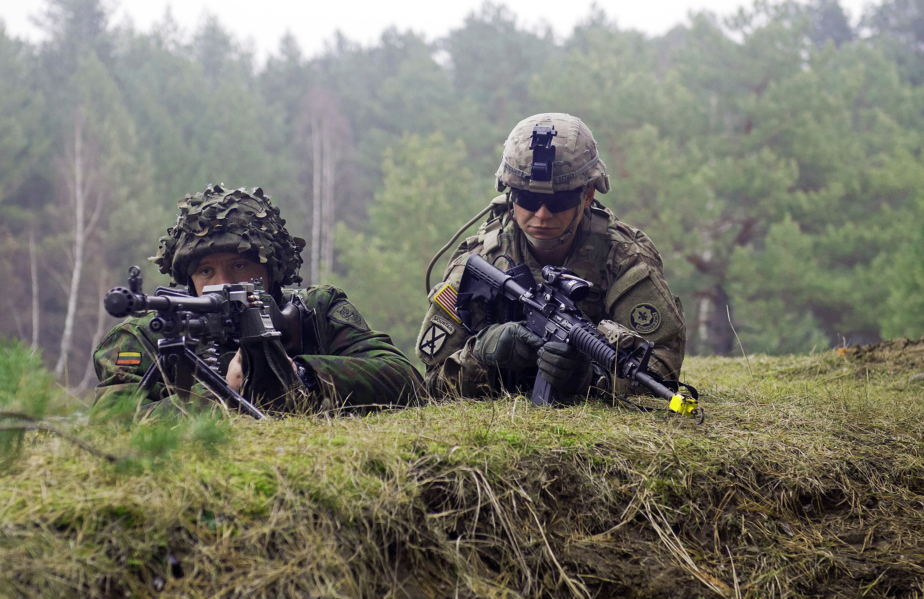 Spc. Shawn Betschart of 3rd Platoon, Lightning Troop, 3rd Squadron, 2nd Cavalry Regiment, secures the perimeter with a Lithuanian counterpart during an offensive operations exercise at the Pabrade training area in February in Lithuania. U.S. troops and Lithuanian soldiers of 3rd Company, Algirdas Mechanized Infantry Battalion, worked together in a three-day field training exercise in support of Operation Atlantic Resolve. (Photo by Staff Sgt. Megan Leuck)