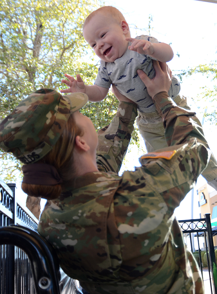 Spc. Christina Shields of Headquarters and Headquarters Company, 47th Brigade Support Battalion, 2nd Brigade, 1st Armored Division, plays with her 10-month-old, John Henry Jr., at Freedom Crossing, an outdoor shopping center at Fort Bliss, Texas. (Photos by Meghan Portillo / NCO Journal)