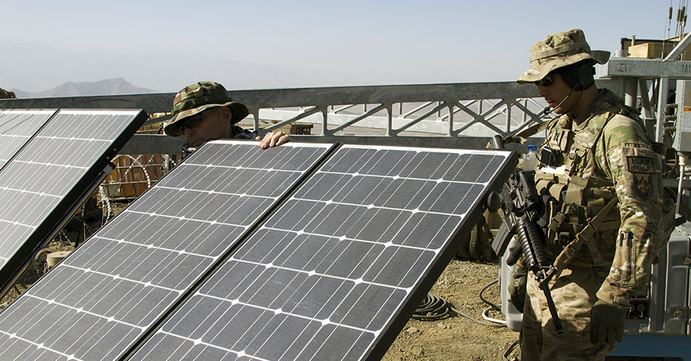 A contractor with the Rapid Equipping Force, left, shows Capt. Steven Caldwell  how to adjust solar panels to increase solar energy collection in September 2014 in  Afghanistan. (Photo by Sgt. William White / U.S. Army)