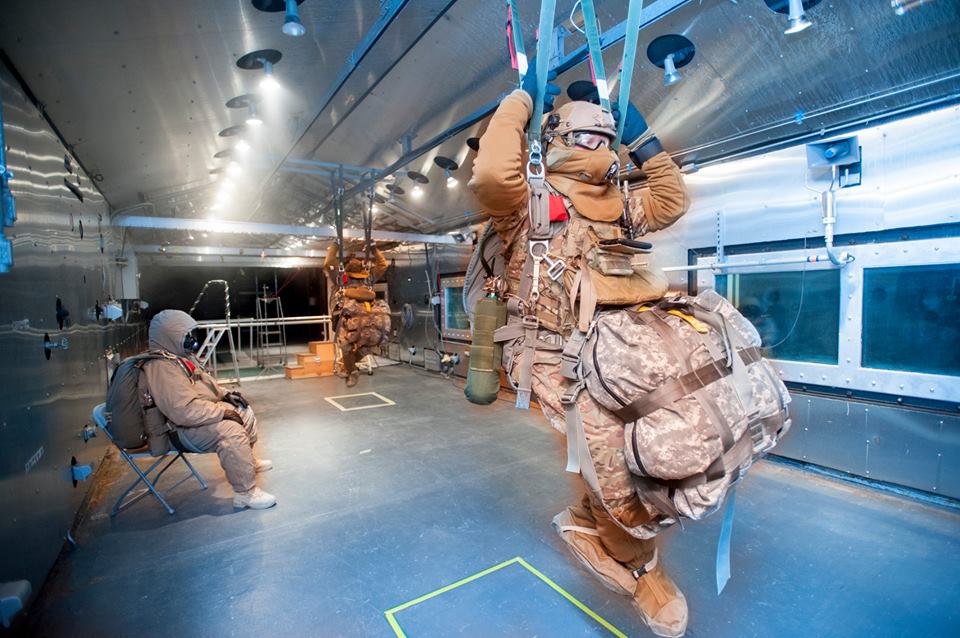 Noncommissioned officers help Aerial Delivery Directorate researchers test the RA-1 parachute’s harness for comfort and fit in the Doriot Climactic Chamber’s Arctic unit. (Photo courtesy of U.S. Army Natick Soldier Research, Development and Engineering Center)