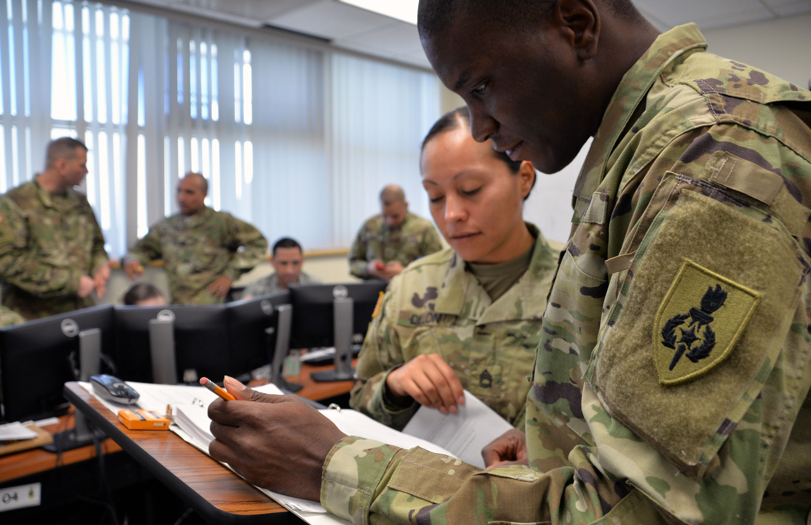 Staff Sgt. Timothy D. Hughes and Sgt. 1st Class Tannia I. Dillon review their notes during a Battle Staff Noncommissioned Officer Course exercise in the spring at the U.S. Army Sergeants Major Academy at Fort Bliss, Texas. (Photo by Martha C. Koester / NCO Journal)