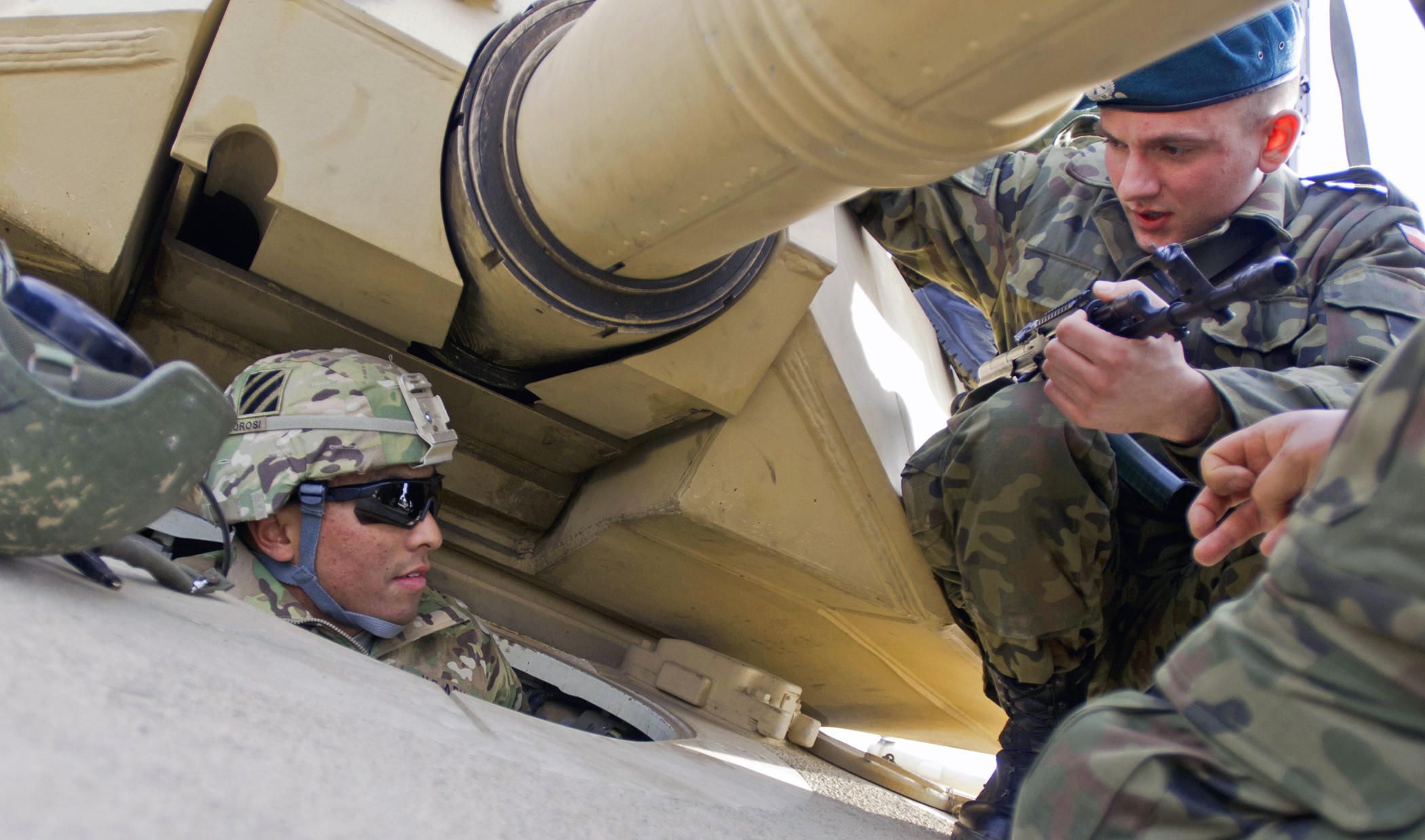 Pfc. John Morosi, assigned to the “Death Riders” Company, 2nd Battalion, 7th Infantry Regiment, 1st Armor Brigade Combat Team, 3rd Infantry Division, familiarizes his Polish counterparts on the finer points of the M1 Abrams Main Battle Tank during Operation Atlantic Resolve in March. (Photo by Staff Sgt. Cooper T. Cash)