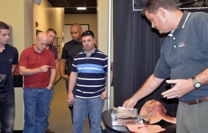 Science and technology manager Bill Pike, right, shows NCOs simple entry and exit wounds used for medical simulation training
