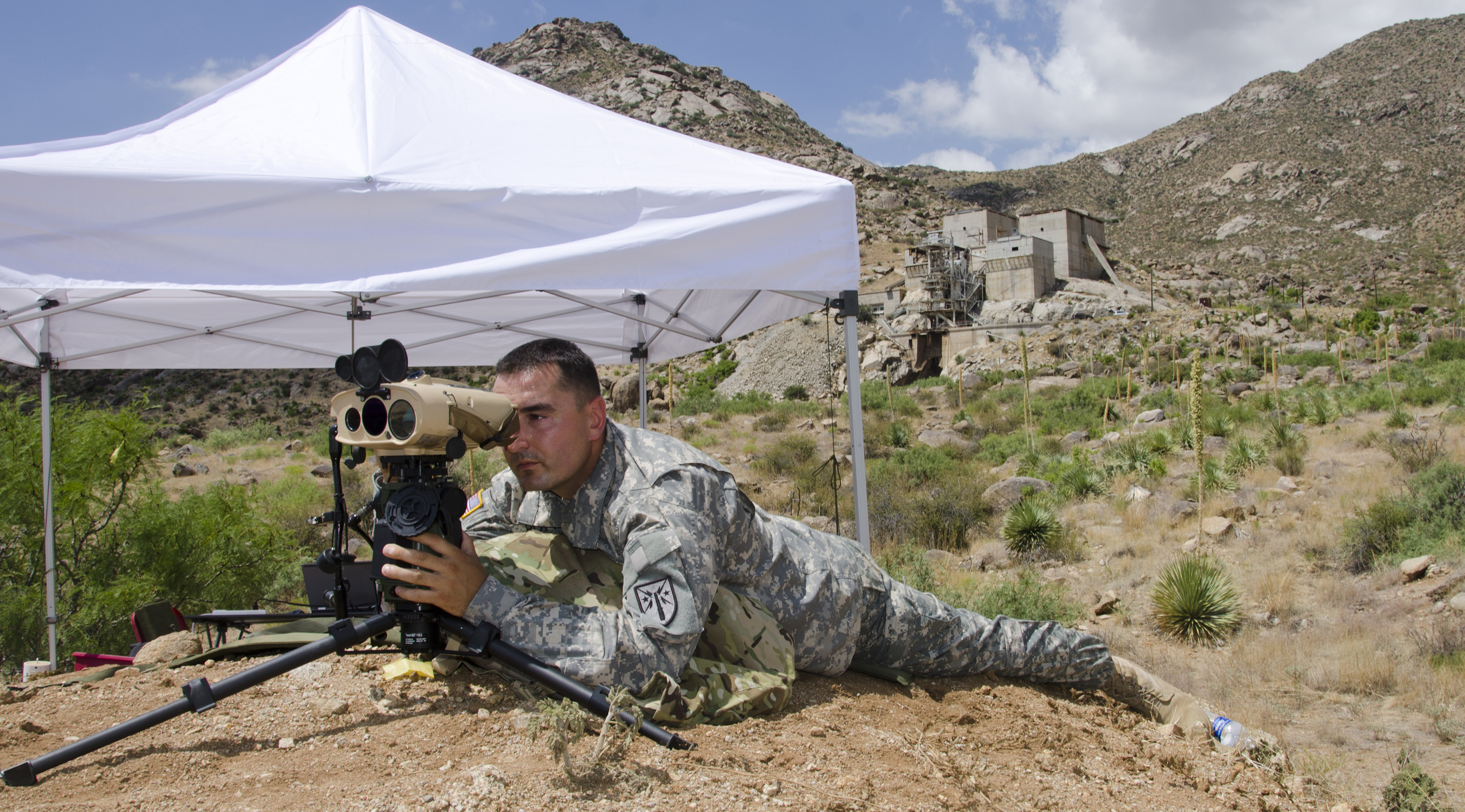 Sgt. 1st Class Justin Rotti, a combat developer for the U.S. Army Training and Doctrine Command Fire Cell, tests a developmental handheld precision targeting device for the Rapid Equipping Force in July 2014 at White Sands Missile Range, New Mexico. The device allows Soldiers to engage targets with precision munitions and provide digital connectivity to related units. (Photo by John Hamilton / White Sands Missile Range Public Affairs)