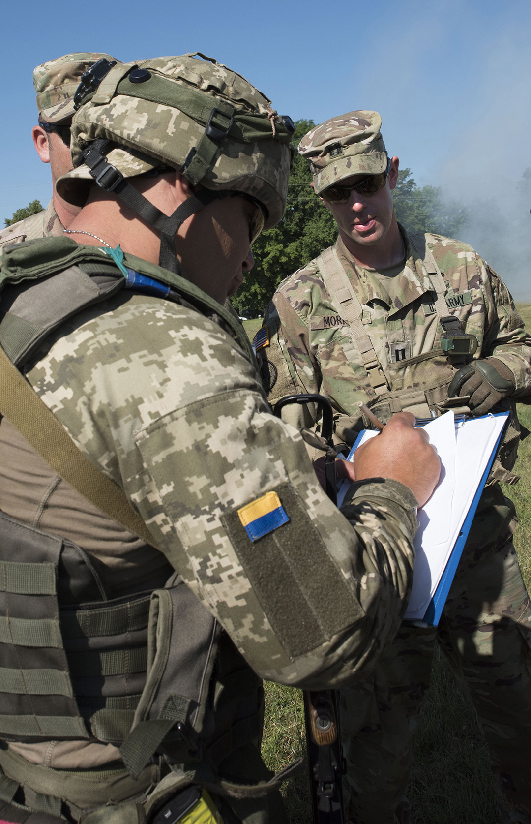 A Ukrainian soldier writes down names of people attempting to enter an entry control point from a U.S. Soldier acting as an Observer Controller Trainer during exercise Rapid Trident 16 July 5, 2016.  (Photo by Sgt. 1st Class Whitney Hughes / U.S. Army)