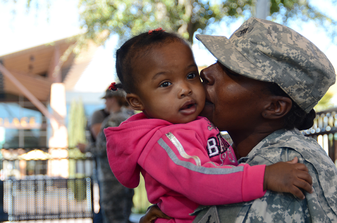 Sgt. Tiana Rumph of Headquarters and Headquarters Company, 1st Stryker Brigade, 1st Armored Division, plays with her 16-month-old, Lillian, at Freedom Crossing, an outdoor shopping center at Fort Bliss, Texas. (Photos by Meghan Portillo / NCO Journal)